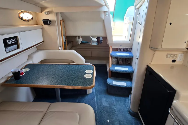 Slide: The Image of Interior of 1995 Sea Ray 330 Sundancer yacht with seating, table, and stairs. - 21