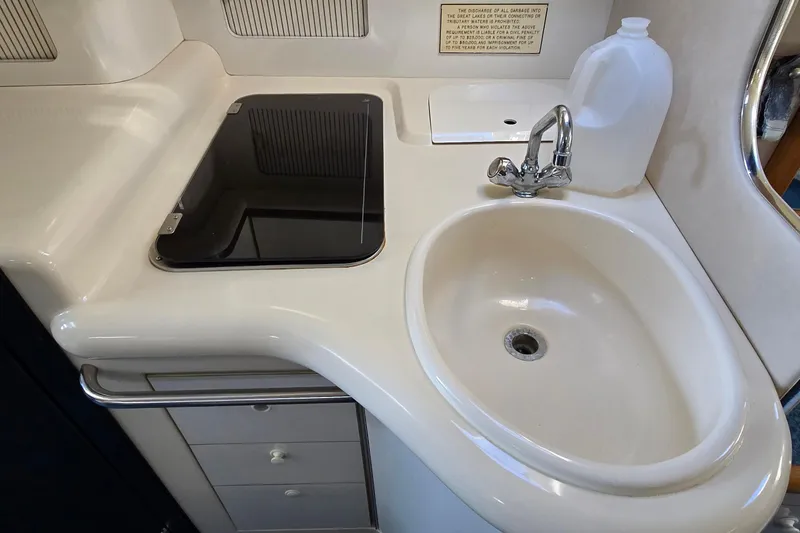 Slide: The Image of 1995 Sea Ray 330 Sundancer kitchen area with sink, faucet, and stove. - 23