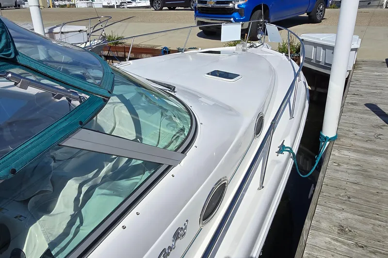 Slide: The Image of 1995 Sea Ray 330 Sundancer docked, featuring sleek white design and teal canopy. - 3