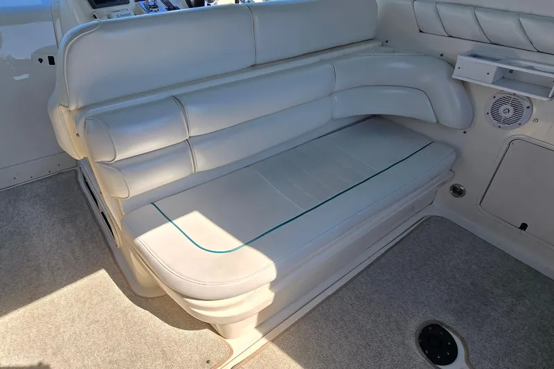 Slide: The Image of 1995 Sea Ray 330 Sundancer interior with white leather seating and carpeted flooring. - 6