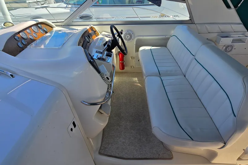 Slide: The Image of 1995 Sea Ray 330 Sundancer cockpit with steering wheel, dashboard, and cushioned seating. - 8
