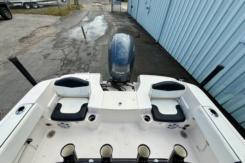 Slide: The Image of 2018 Robalo R180 Center Console boat with Yamaha 150 engine, docked near blue building. - 11