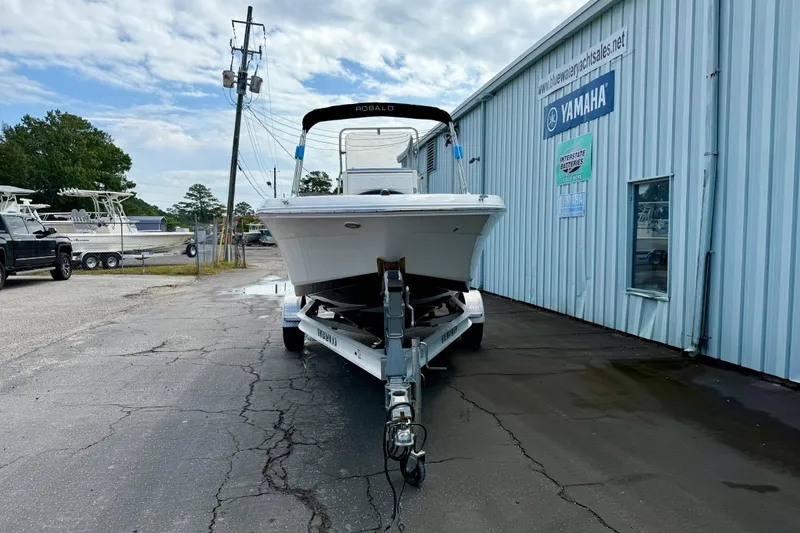 Slide: The Image of 2018 Robalo R180 Center Console boat on trailer outside dealership. - 2