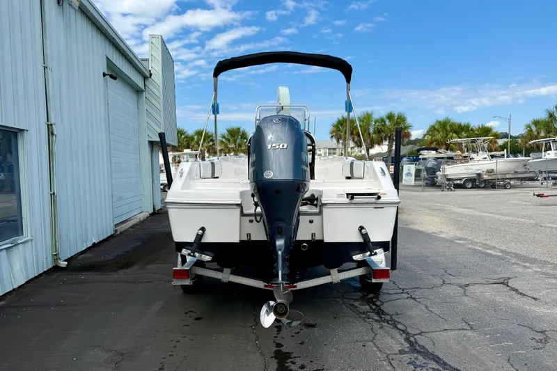 Slide: The Image of 2018 Robalo R180 Center Console boat with 150 HP engine, parked outdoors. - 4