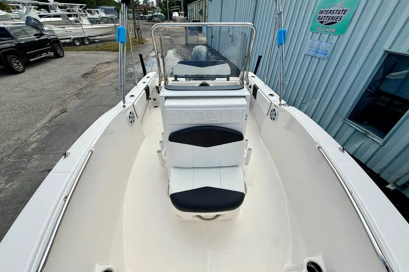 Slide: The Image of 2018 Robalo R180 Center Console boat, white interior, docked near a building. - 9