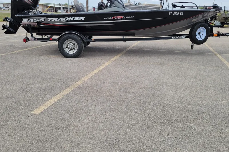 Slide: The Image of 2014 Tracker Pro Team 175 TXW bass boat on trailer in parking lot. - 3