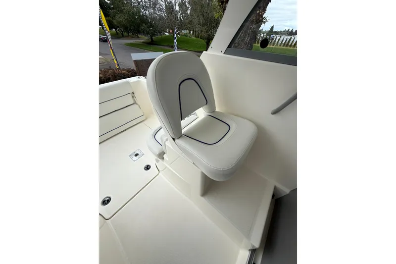 Slide: The Image of 2007 Bayliner 246 Discovery boat interior with white cushioned seating. - 12