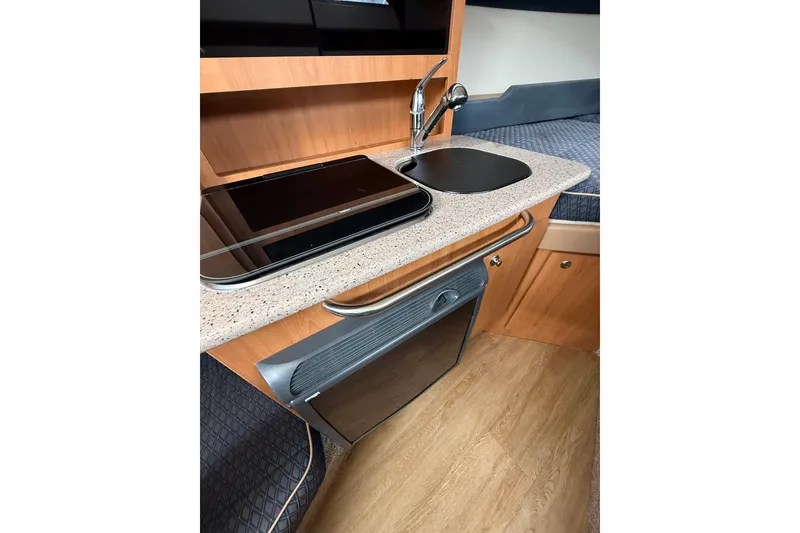 Slide: The Image of 2007 Bayliner 246 Discovery boat interior with kitchenette, sink, and stove. - 18