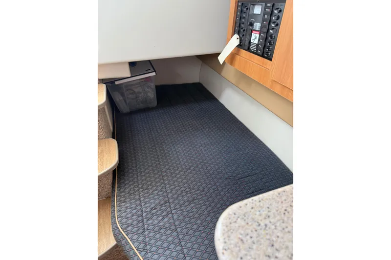 Slide: The Image of 2007 Bayliner 246 Discovery cabin interior with control panel and carpeted floor. - 20