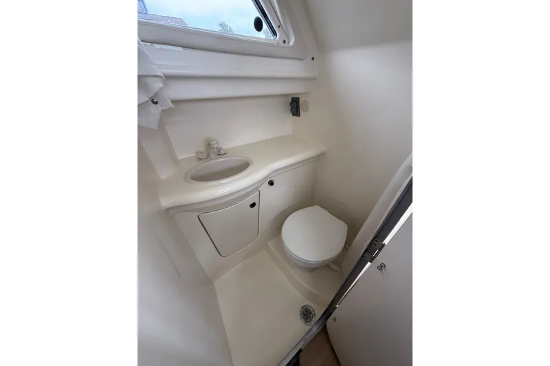 Slide: The Image of Compact bathroom in 2007 Bayliner 246 Discovery boat, featuring sink and toilet. - 22