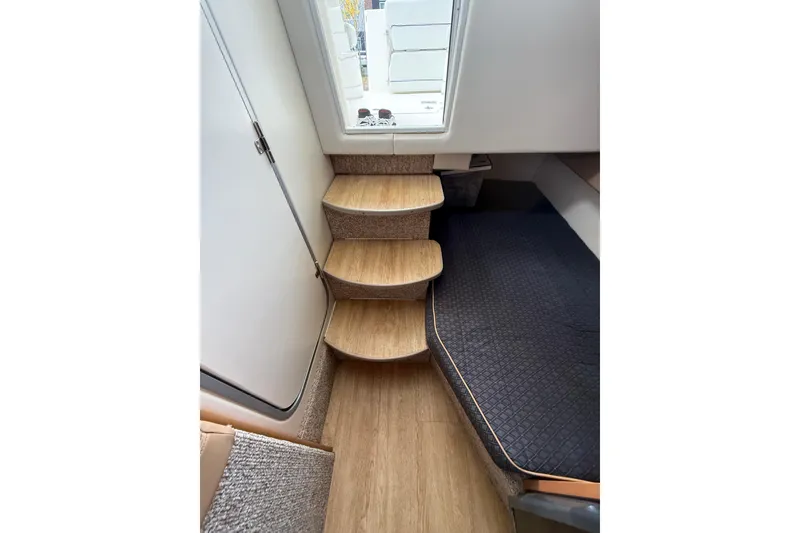 Slide: The Image of Interior of 2007 Bayliner 246 Discovery boat with wooden steps and cozy cabin space. - 23