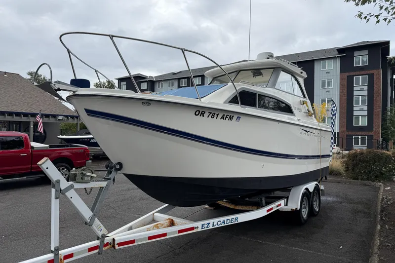 Slide: The Image of 2007 Bayliner 246 Discovery boat on trailer in parking lot. - 3