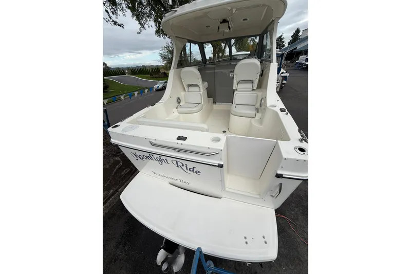 Slide: The Image of 2007 Bayliner 246 Discovery boat with spacious cockpit and seating, docked outdoors. - 7