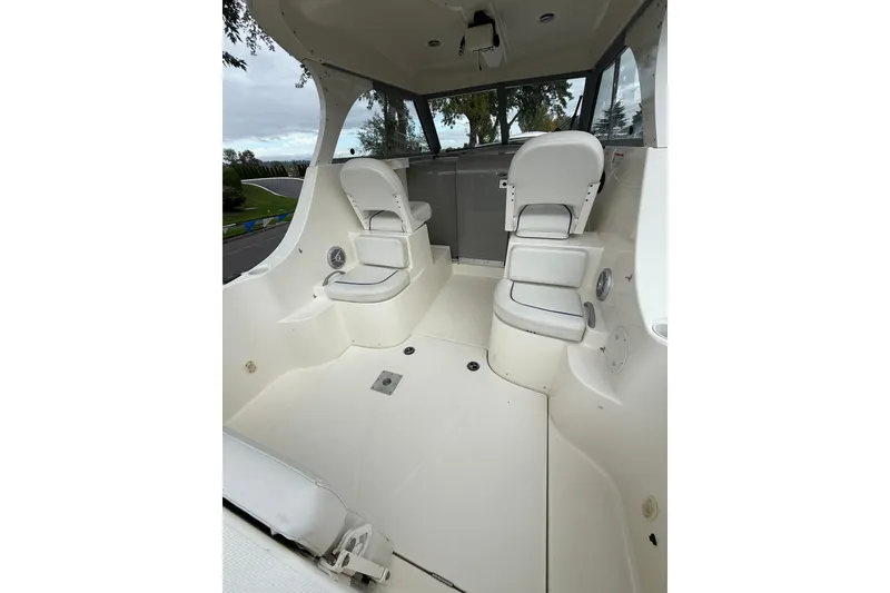 Slide: The Image of 2007 Bayliner 246 Discovery boat interior with white seating and spacious layout. - 8