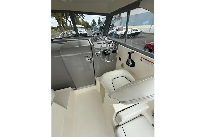 Slide: The Image of Interior of 2007 Bayliner 246 Discovery boat, featuring helm and seating area. - 9