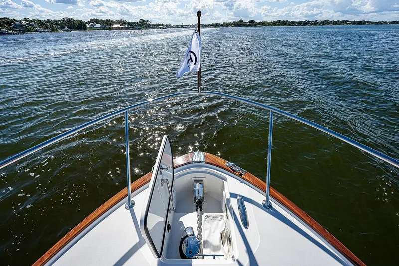 Slide: The Image of Bow view of 2023 Hinckley 40x yacht on open water under a sunny sky. - 10