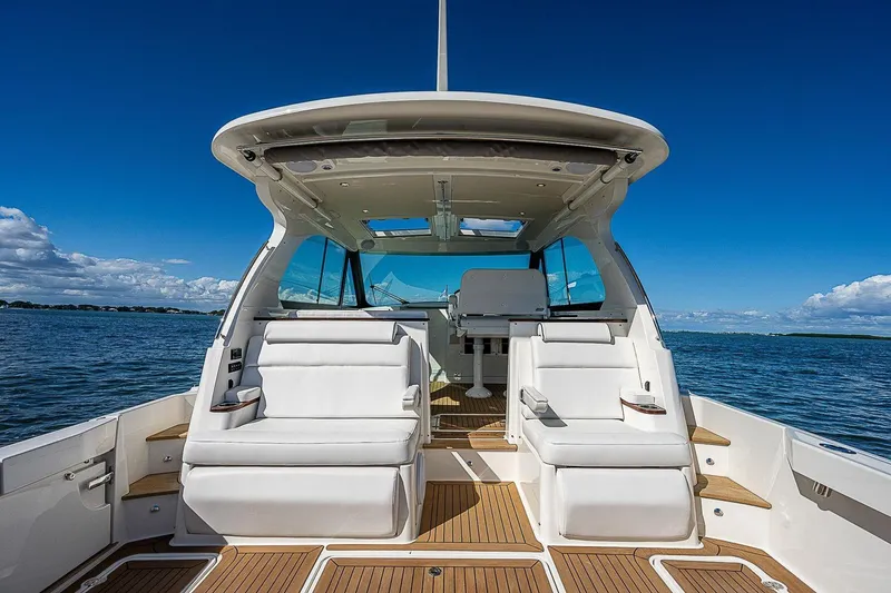 Slide: The Image of 2023 Hinckley 40x yacht interior with white seating, wooden deck, and ocean view. - 11