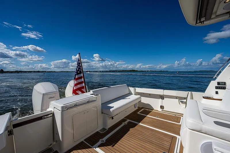 Slide: The Image of Hinckley 40x 2023 yacht deck with American flag, ocean view, and clear blue sky. - 12
