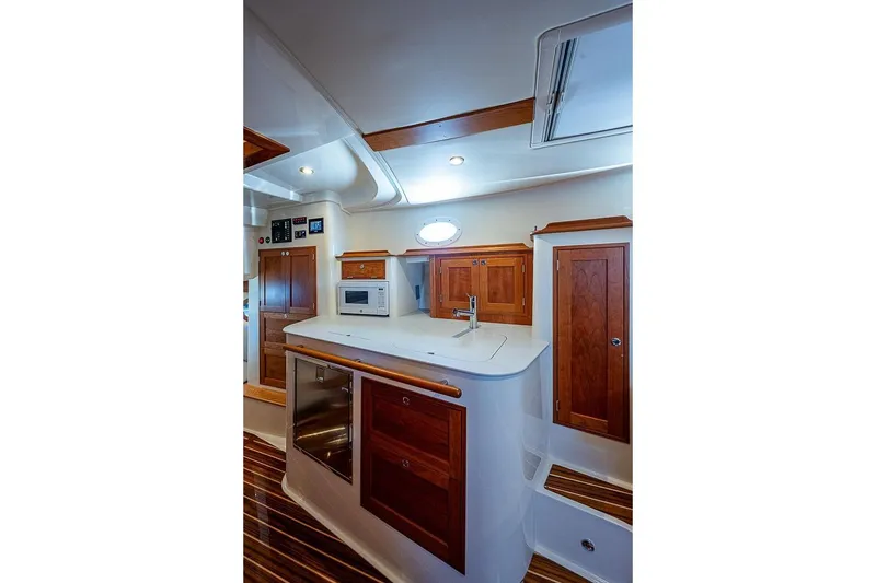 Slide: The Image of Luxurious 2023 Hinckley 40x yacht interior with modern kitchen and wooden cabinetry. - 17