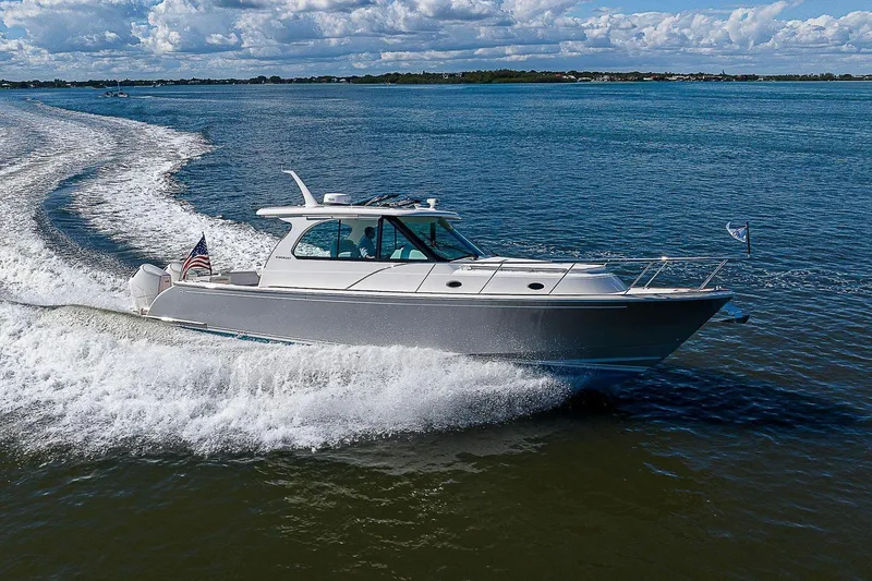 Slide: The Image of 2023 Hinckley 40x boat cruising on open water under a partly cloudy sky. - 6