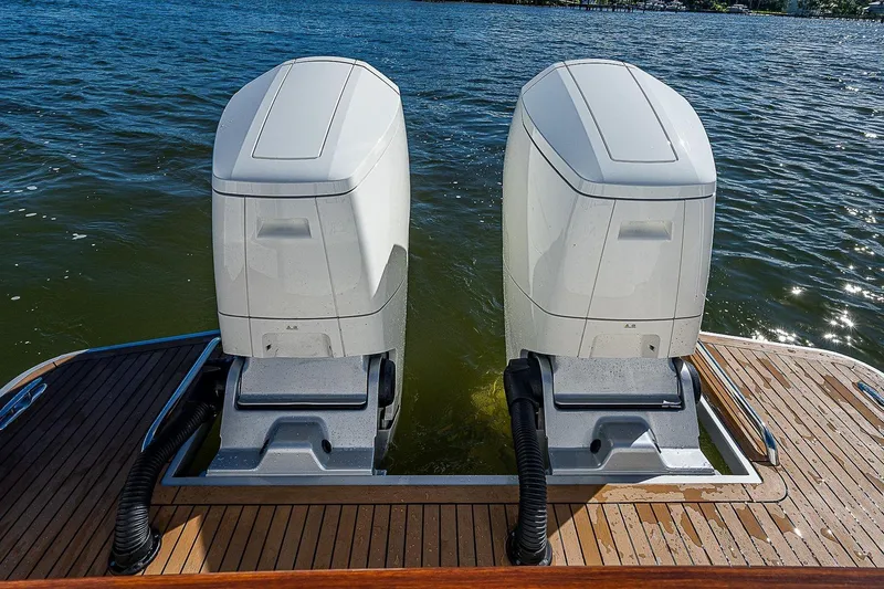 Slide: The Image of Twin outboard engines on a 2023 Hinckley 40x boat, docked on a sunny day. - 9