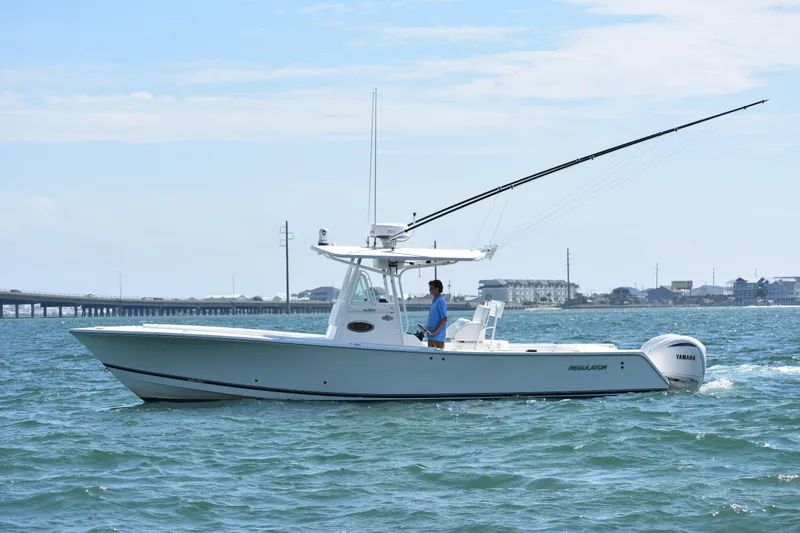 The Image of 2008 Regulator 32 Forward Seating boat cruising on open water with bridge in background. - 0
