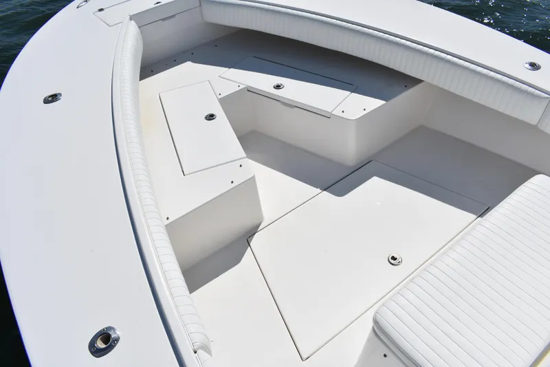 Slide: The Image of 2008 Regulator 32 Forward Seating boat interior with white cushioned seats and storage compartments. - 11