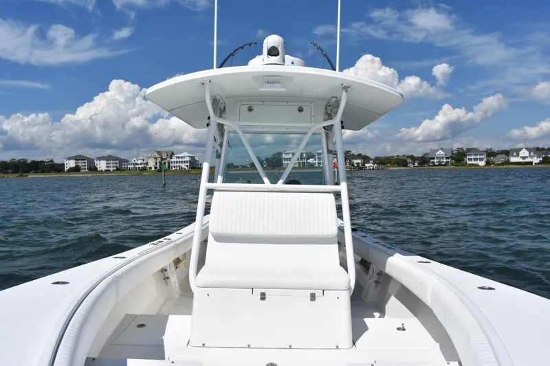 Slide: The Image of 2008 Regulator 32 Forward Seating boat on water, with coastal homes in the background. - 12