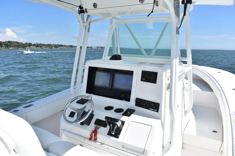 Slide: The Image of 2008 Regulator 32 Forward Seating boat dashboard with steering wheel and navigation screens. - 18