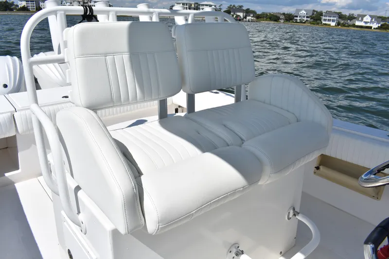 Slide: The Image of 2008 Regulator 32 Forward Seating boat with white cushioned seats on a sunny day. - 23