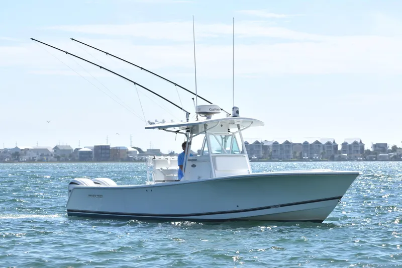 Slide: The Image of 2008 Regulator 32 Forward Seating boat on water, coastal town in background. - 3