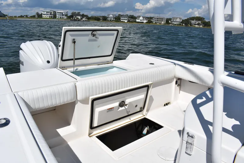 Slide: The Image of 2008 Regulator 32 Forward Seating boat with open storage compartments on calm water. - 32