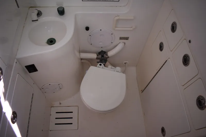Slide: The Image of 2008 Regulator 32 Forward Seating boat bathroom with sink, toilet, and storage compartments. - 40