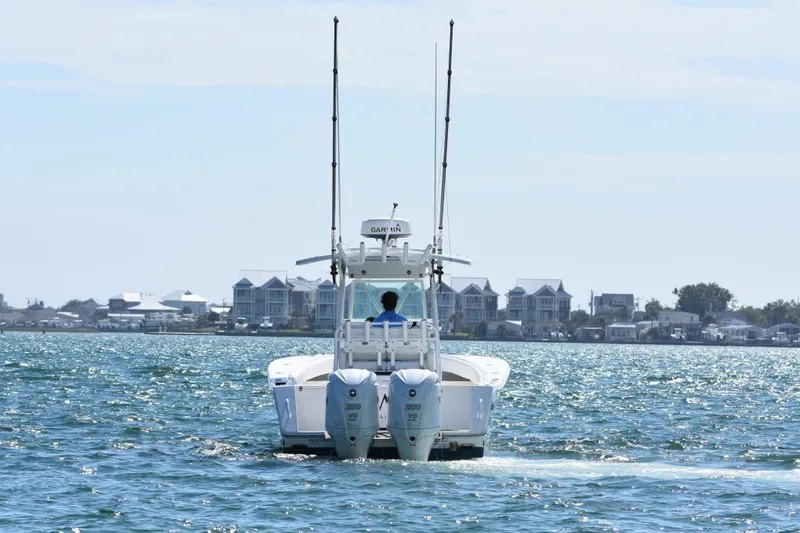 Slide: The Image of 2008 Regulator 32 Forward Seating boat cruising on a sunny day near coastal homes. - 6