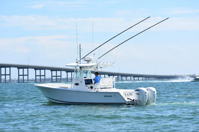 Slide: The Image of 2008 Regulator 32 Forward Seating boat on water near a bridge, clear sky. - 7