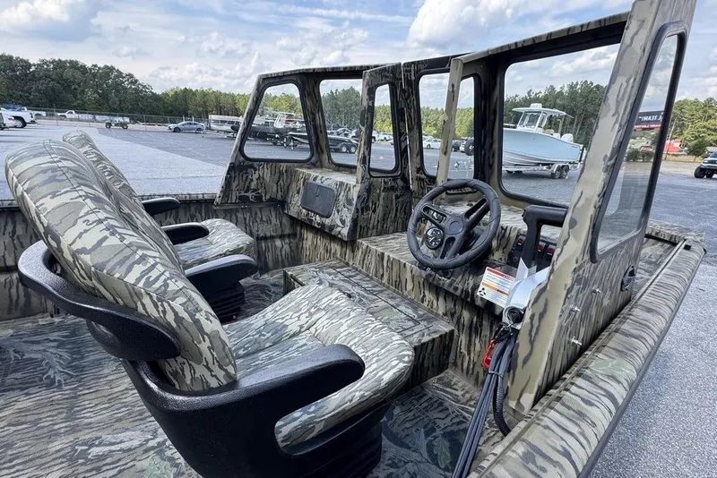 Slide: The Image of 2026 SeaArk 2272 MV FlatKat boat interior with camouflage seating and steering console. - 3