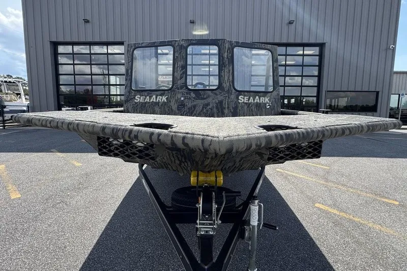 Slide: The Image of 2026 SeaArk 2272 MV FlatKat boat with camouflage design, parked outside a building. - 4