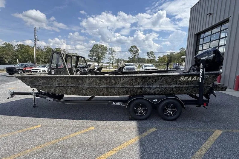 Slide: The Image of 2026 SeaArk 2272 MV FlatKat boat with camouflage design on a trailer, parked outdoors. - 5