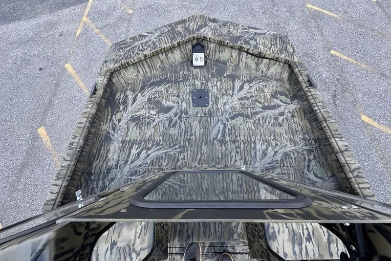 Slide: The Image of 2026 SeaArk 2272 MV FlatKat boat with camouflage pattern, viewed from above in a parking lot. - 9