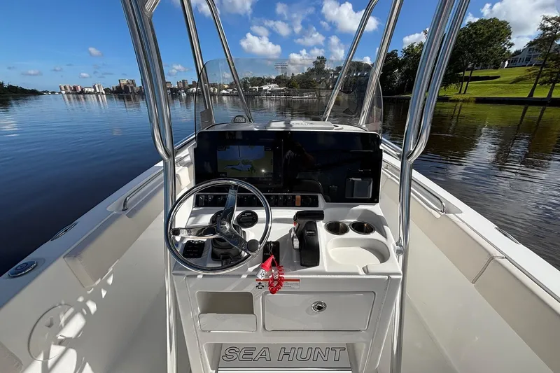Slide: The Image of 2020 Seahunt 234 Ultra boat console with steering wheel, controls, and water view. - 8