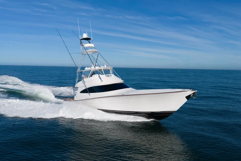 The Image of 2019 Viking 68 Convertible yacht cruising on open sea under clear blue sky. - 0