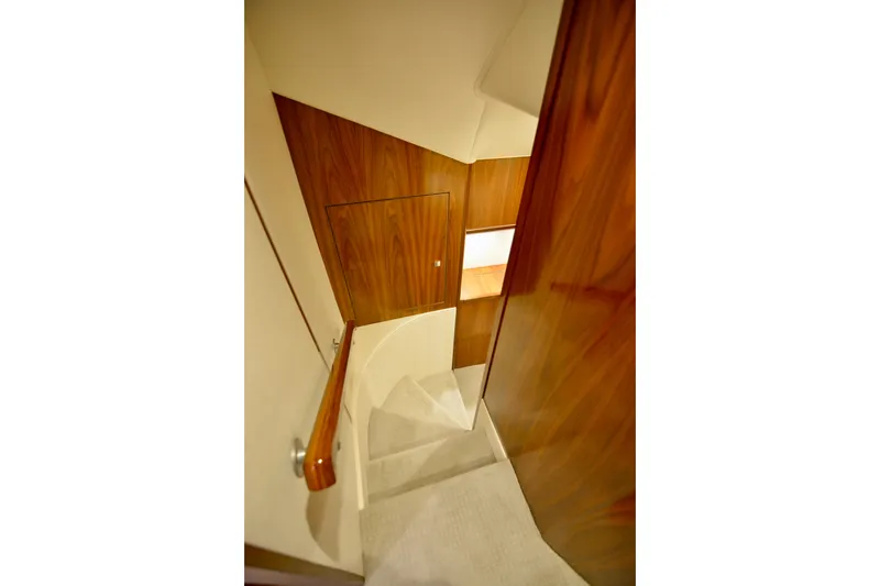 Slide: The Image of Interior staircase of 2019 Viking 68 Convertible yacht with wooden paneling. - 15