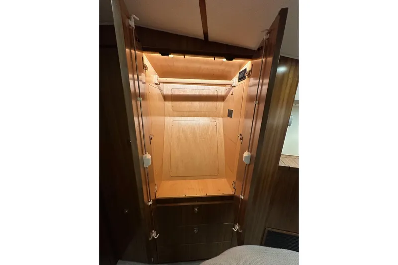 Slide: The Image of 2019 Viking 68 Convertible yacht interior closet with wooden finish and lighting. - 22