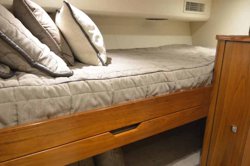 Slide: The Image of Cozy cabin bed in 2019 Viking 68 Convertible yacht with wooden accents and plush pillows. - 24