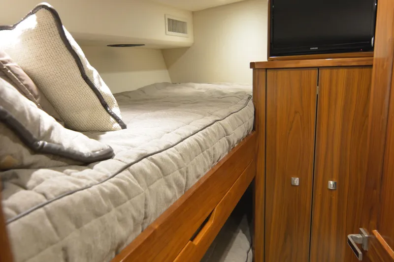 Slide: The Image of Cozy cabin interior of 2019 Viking 68 Convertible yacht with bed and wooden cabinetry. - 25