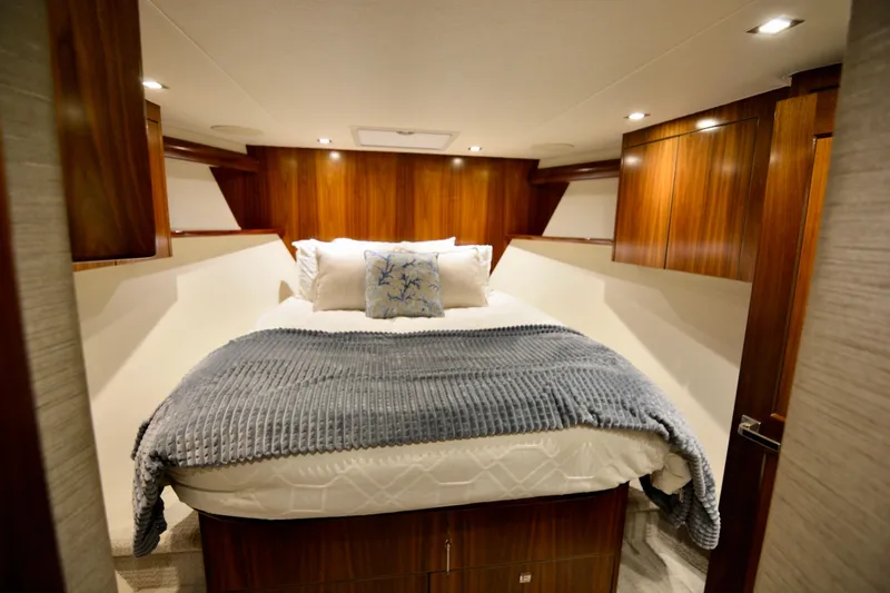 Slide: The Image of Luxurious bedroom interior of 2019 Viking 68 Convertible yacht with cozy bedding and wooden accents. - 27