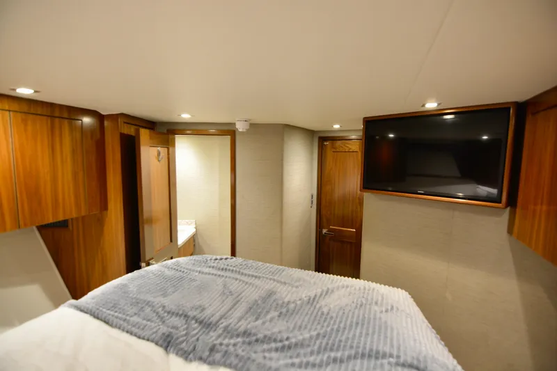 Slide: The Image of Luxurious cabin interior of 2019 Viking 68 Convertible yacht with TV and wood finishes. - 28