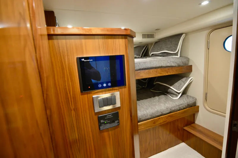 Slide: The Image of 2019 Viking 68 Convertible yacht interior with bunk beds and control panel. - 33