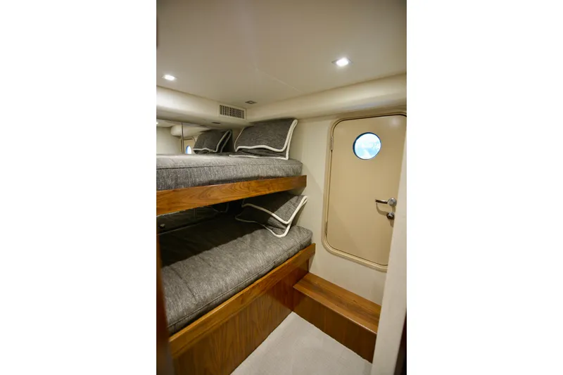 Slide: The Image of Interior of 2019 Viking 68 Convertible yacht with bunk beds and porthole door. - 34