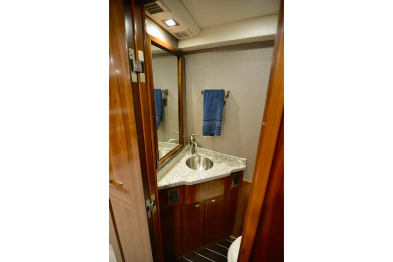 Slide: The Image of Luxurious bathroom in 2019 Viking 68 Convertible yacht with granite countertop and wooden cabinetry. - 4